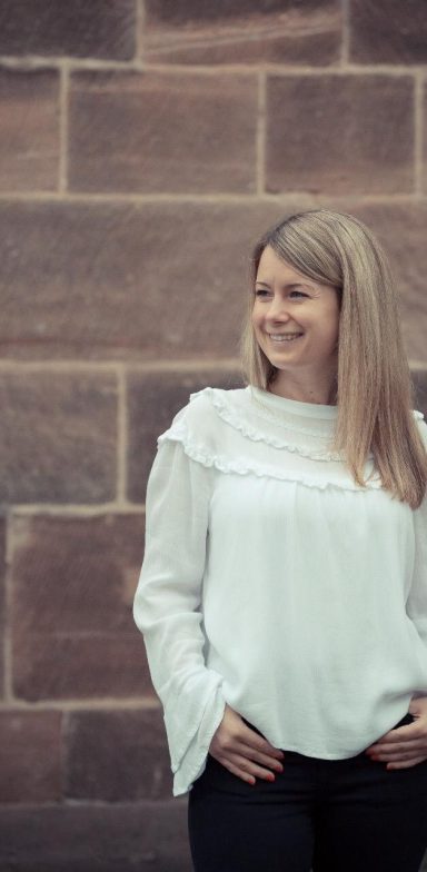 Julia Grace is standing in front of a wall